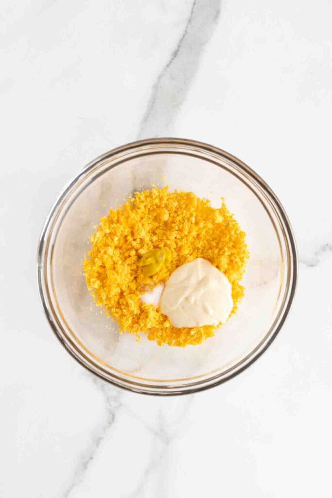 Miracle whip being added to mixed up egg yolk.