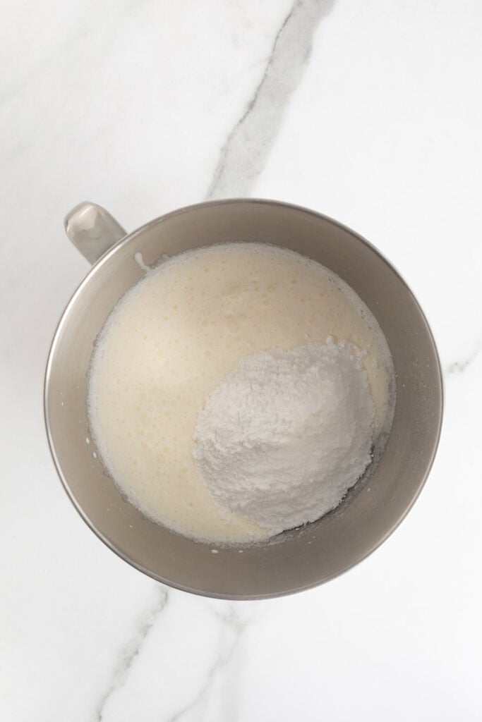 Heavy cream and powdered sugar in a mixing bowl