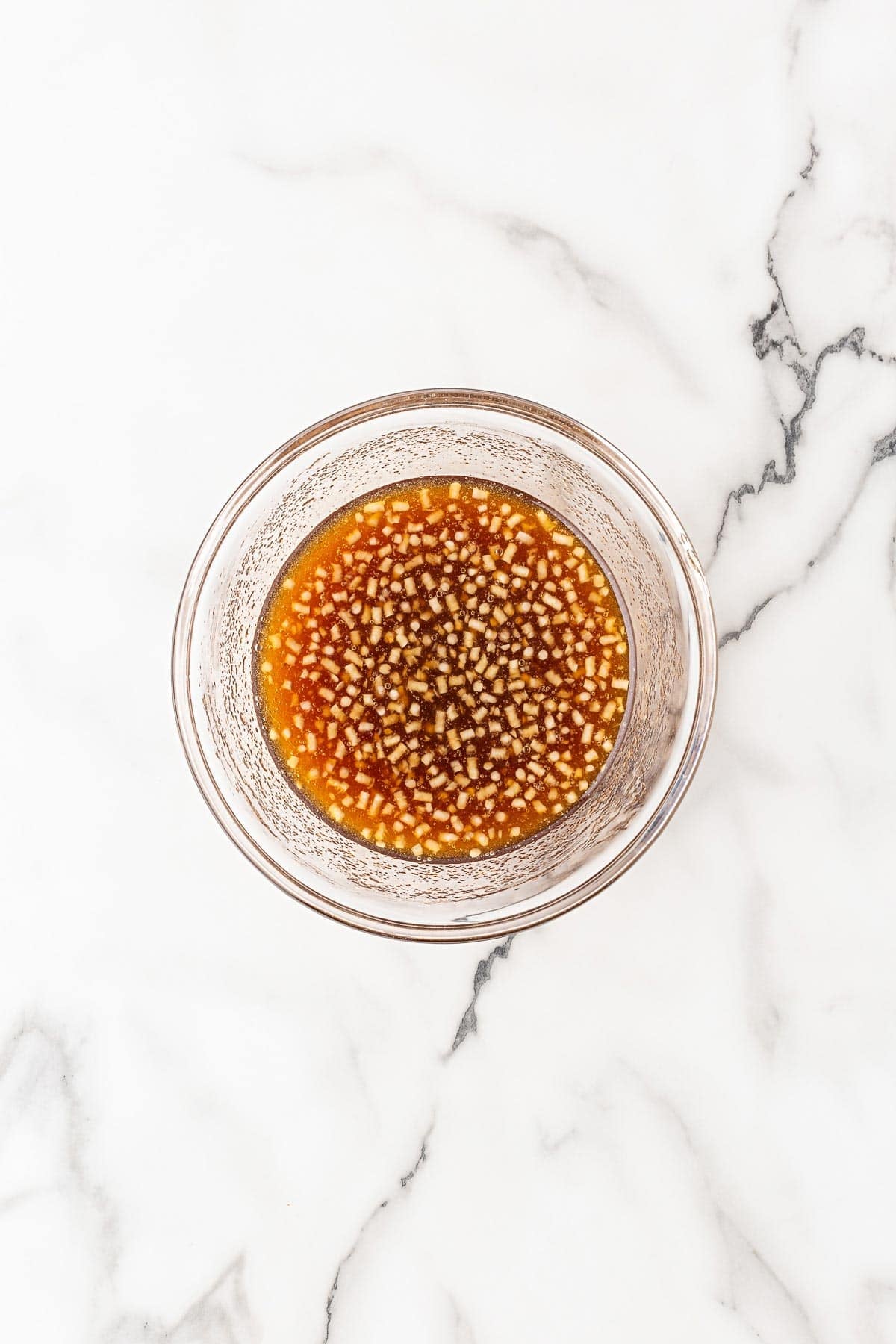 Bowl of honey glaze mixed on a marble countertop