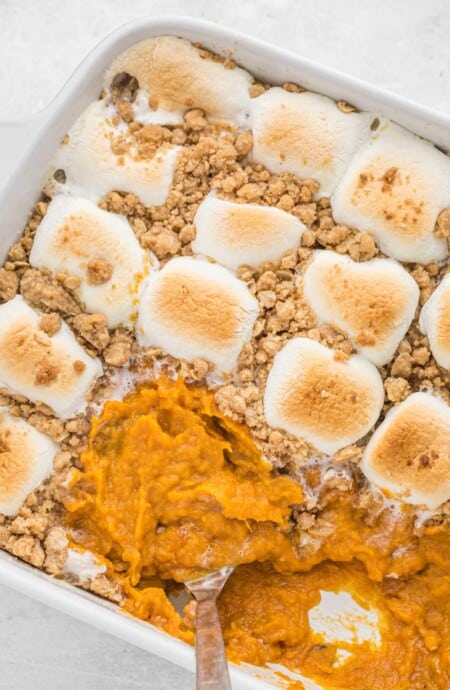 Southern sweet potato casserole recipe on the table with a spoon scooping a serving.