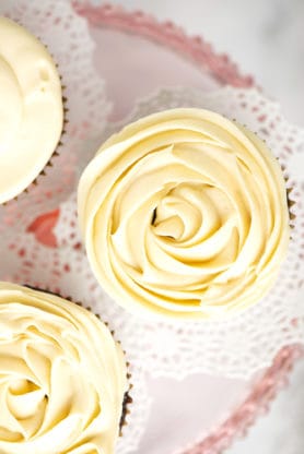 A close up of frosting piped on cupcake like a rose