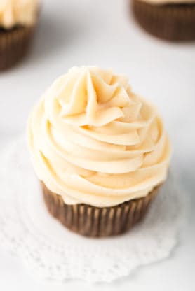 A close up of cupcake with caramel buttercream swirled high on top