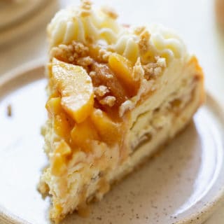 A perfect slice of peach cobbler cheesecake on a plate ready to eat