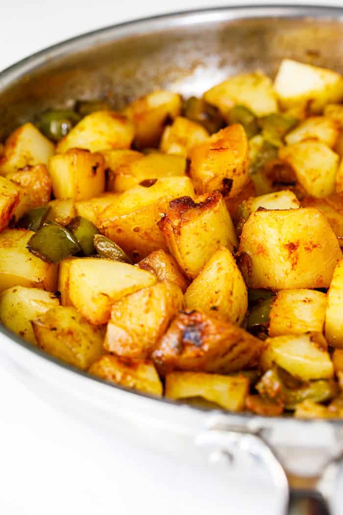 A close up of southern potatoes smothered with green peppers and onions ready to serve
