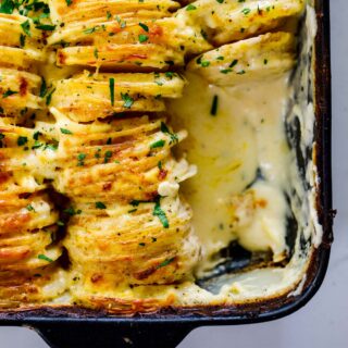 Spoon serving cheesy baked potatoes to guests