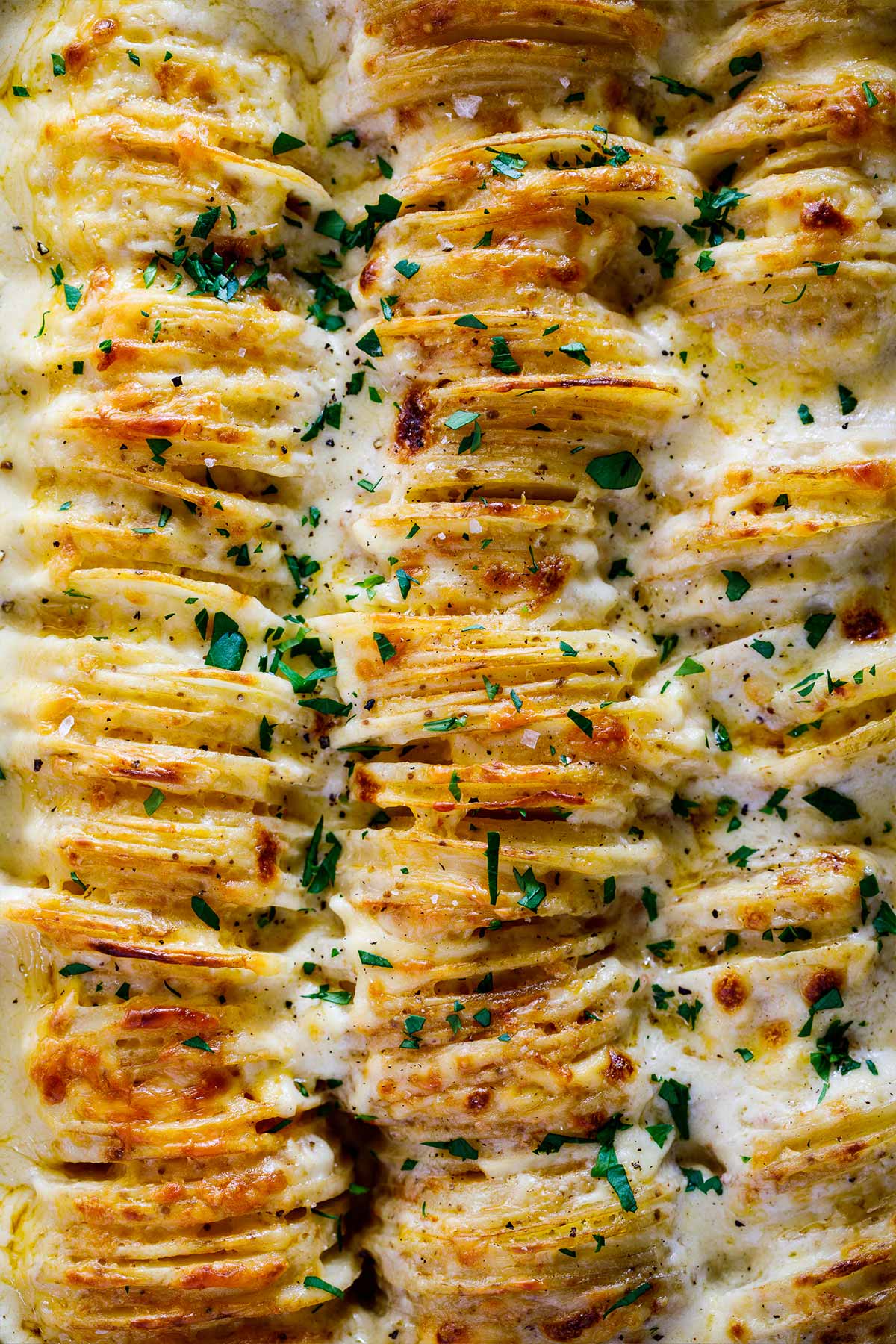 Overhead of scalloped potatoes in casserole dish with a serving missing.