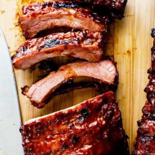 A close up of bbq ribs sliced and ready to serve with barbecue sauce