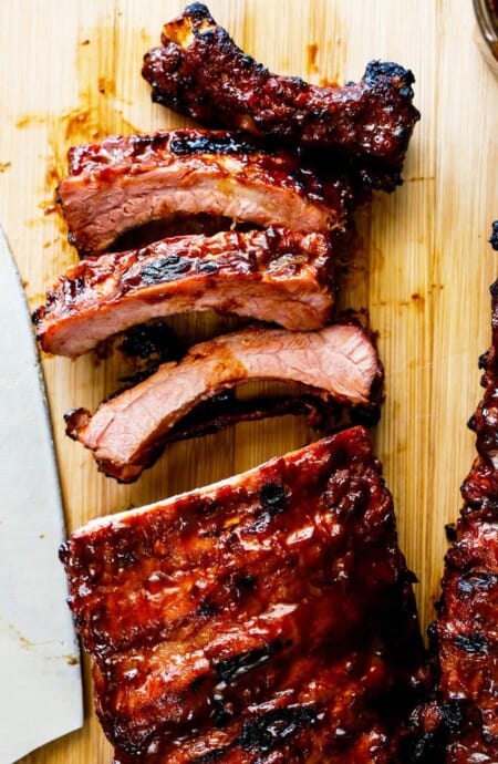 A close up of bbq ribs sliced and ready to serve with barbecue sauce