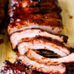 A close up of bbq baby back ribs ready to serve with sauce on top