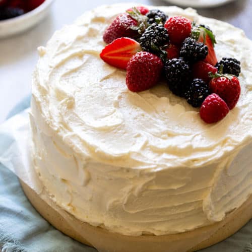 a devil's food cake frosted with swiss meringue buttercream and topped with fresh berries