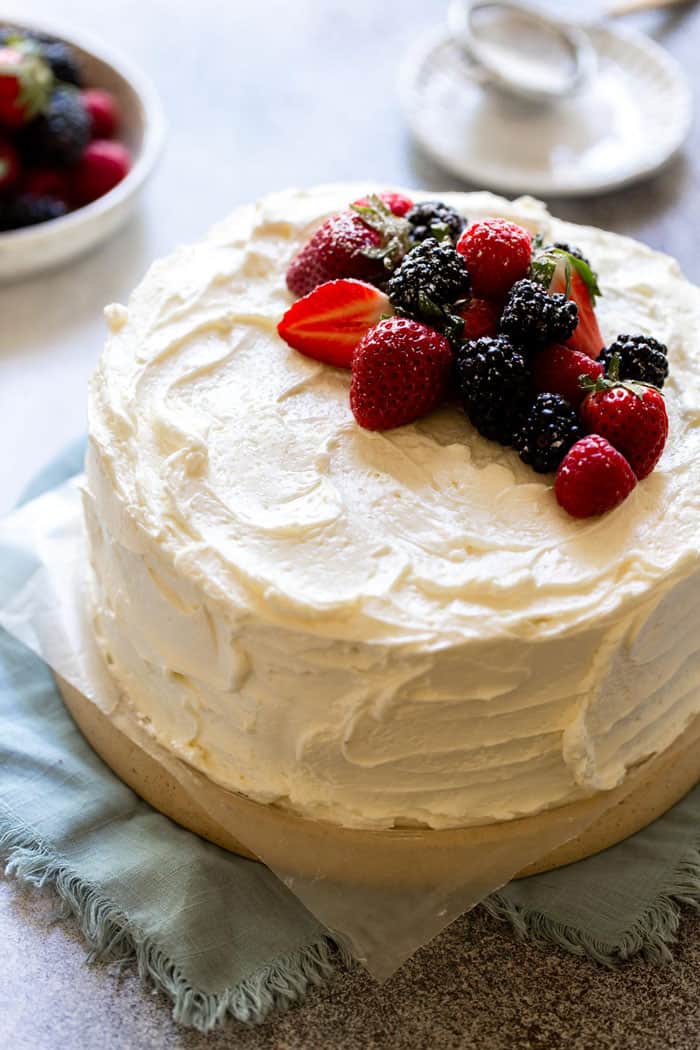 a devil's food cake frosted with swiss meringue buttercream and topped with fresh berries