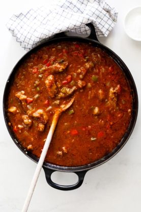 A large pot of tomato sauce and Cajun grillades