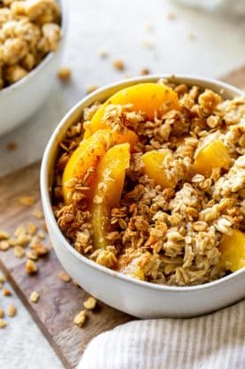 A large bowl of delicious oatmeal with peaches and honey ready to eat for breakfast