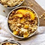 Delicious bowls of peach oatmeal with rolled oats and fresh peaches on table for breakfast