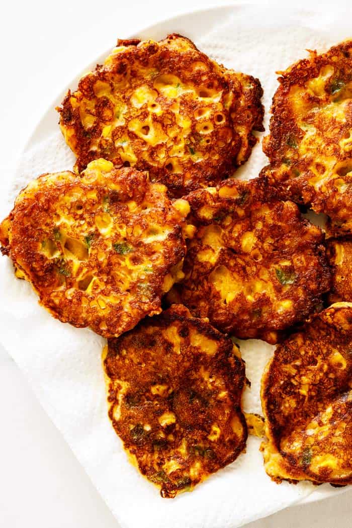 Corn cakes scattered on a white plate after just being fried