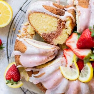 An overhead of a lemonade pound cake with a strawberry swirl slice ready to enjoy