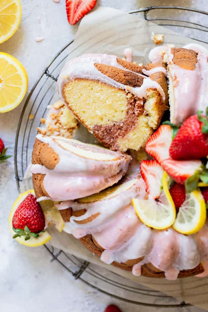 An overhead of a lemonade pound cake with a strawberry swirl slice ready to enjoy
