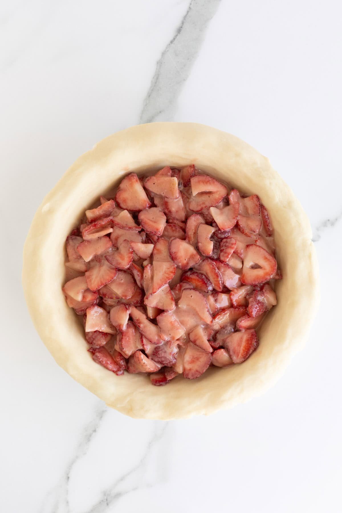 Strawberry filling spread evenly inside the pie crust