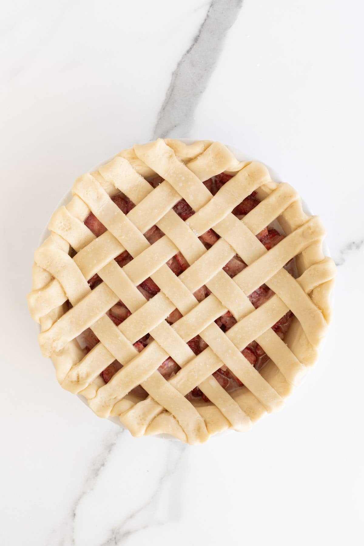 Lattice pie crust sprinkled with coarse sugar before baking