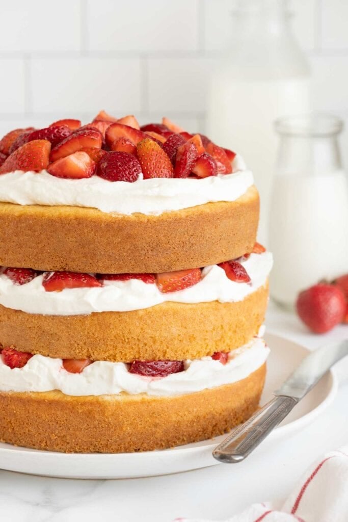 A close up of strawberry shortcake cake recipe on a white plate in white kitchen