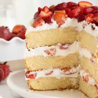 A sliced open strawberry shortcake cake on a white plate