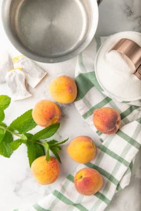 Fresh peaches, mint and tea bags ready to make sweet tea for summer