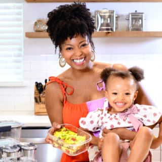 Mother and daughter smiling in kitchen holding frittata in food storage container