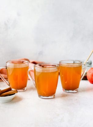apple cider in three mugs ready to serve