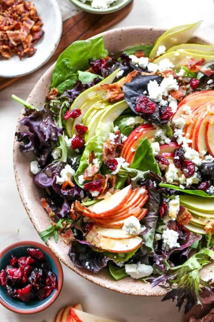 A large bowl of harvest salad with fresh fruit arranged in slices ready to enjoy