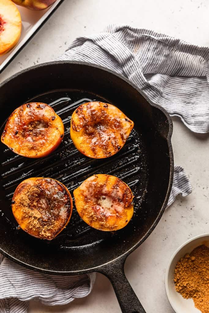 Brown sugar mixture added to tops of grilled peaches
