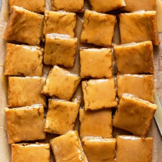 An overhead of 24 maple bars cut and ready to serve on parchment paper