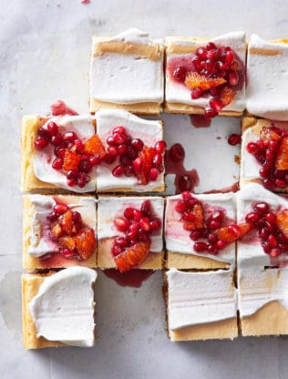 Delicious maple cheesecake cut in squares with red compote on top for serving