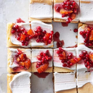 Delicious maple cheesecake cut in squares with red compote on top for serving