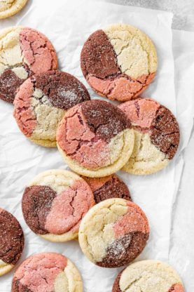 Neapolitan cookies arranged on top of each other against white parchment paper