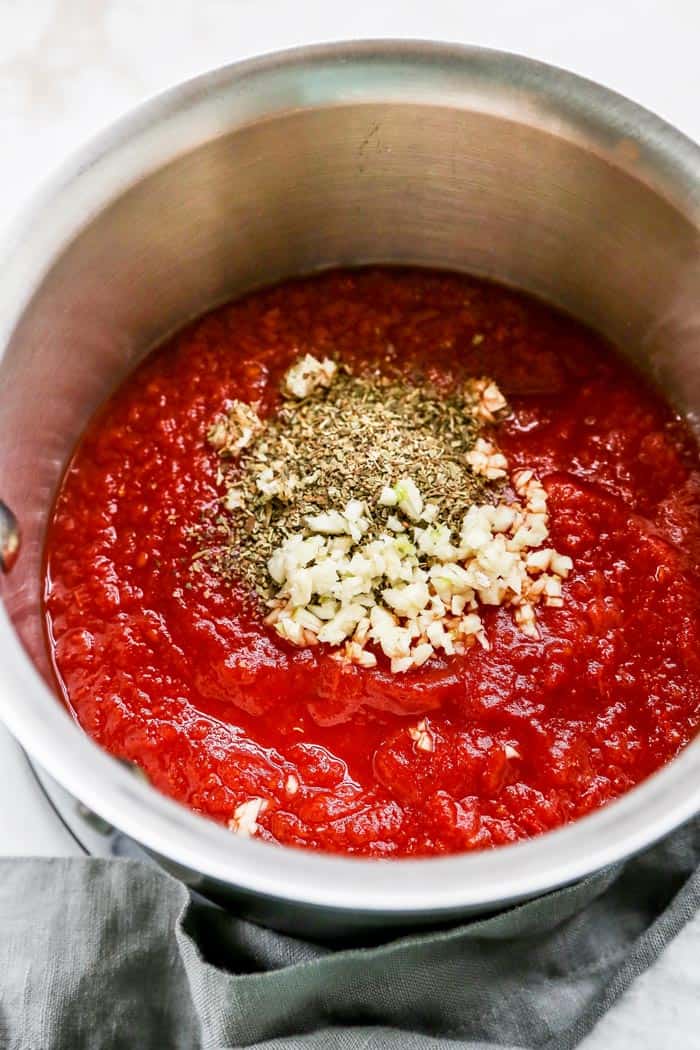 Crushed tomatoes, herbs, spices and garlic ready to make a sauce