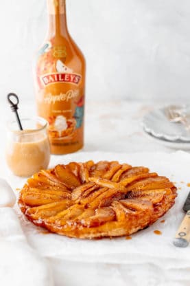A french apple pastry with cream sauce and Baileys Irish Cream against white background