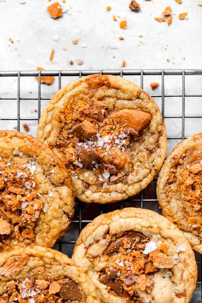 A close up of large brown butter cookies with baked butterfinger and sea salt