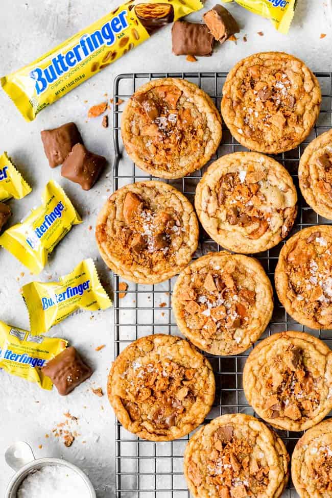 Butteringer cookies on a wire rack with scattered butterfinger candy nearby