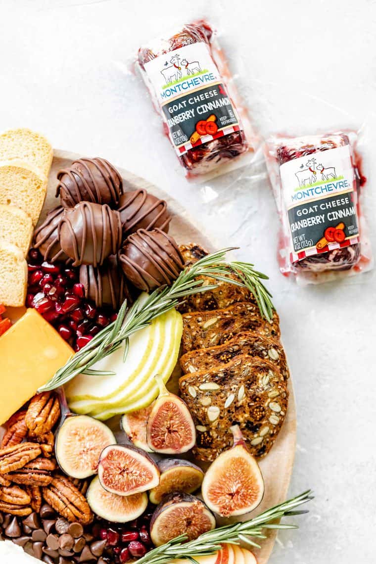 A close up of a dessert board with cranberry goat cheese near by against white background