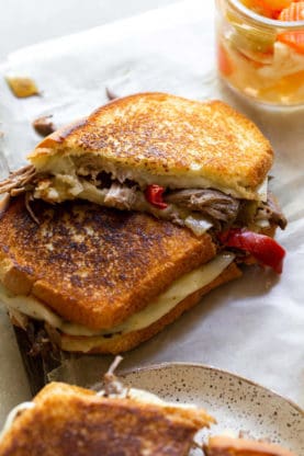 A close up of grilled cheese with crisp bread and beef inside