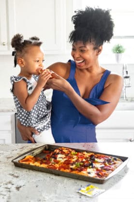Jocelyn Delk Adams feeding her daughter Harmony pizza