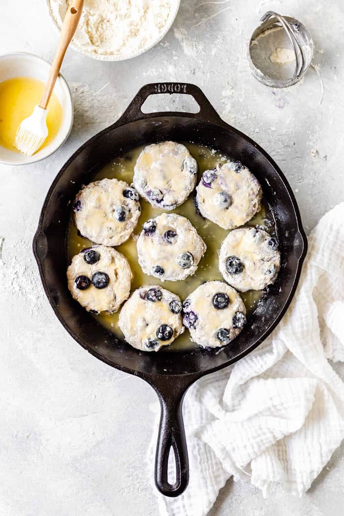 A skillet with biscuit dough with melted butter