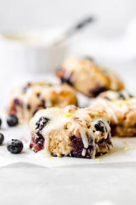 A close up of biscuits with blueberry lemon flavor with glaze on top