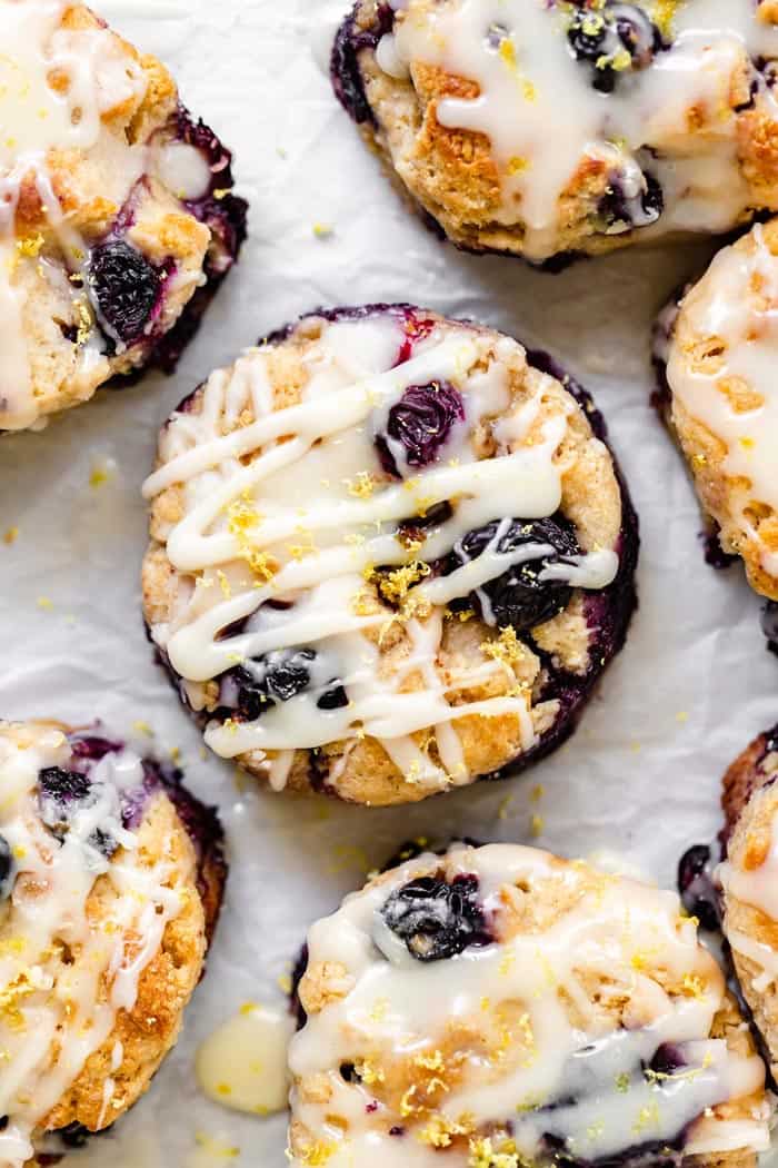 Overhead shot of lemon biscuits filled with fresh blueberries with a vanilla glaze on top