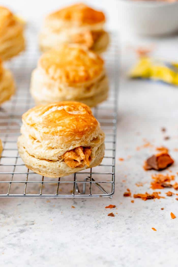 puff pastry cronuts on a wire rack filled with a pumpkin cream with Butterfinger candy