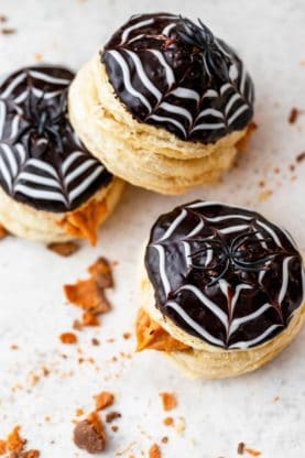 Donuts topped with ganache and a spider web design