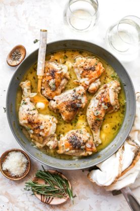 Chicken in a wine garlic sauce with a spoon serving the sauce