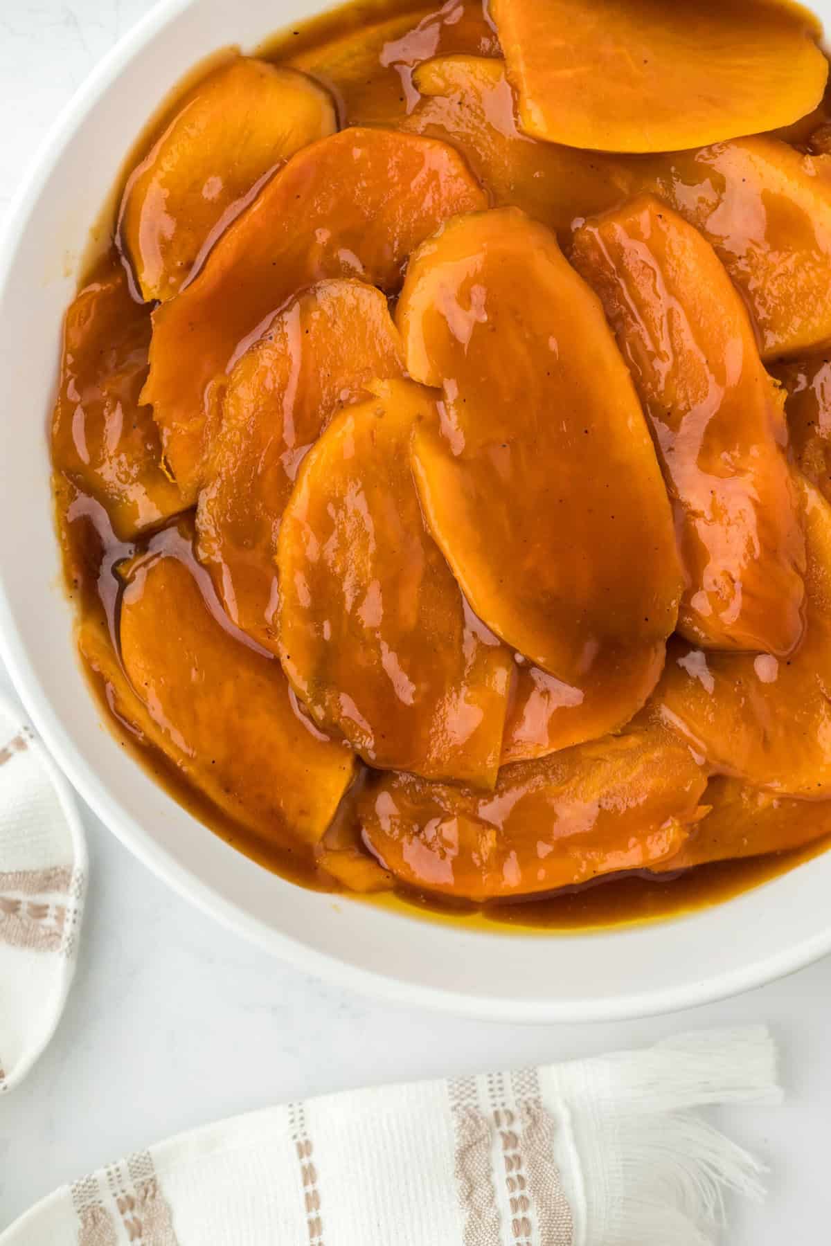 A close up of the best candied sweet potato recipe in a white plate ready to serve