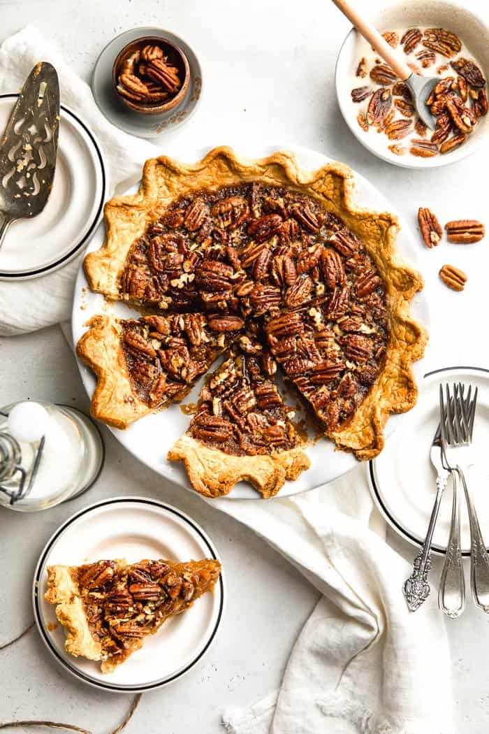 A delicious sweet potato pecan pie completely baked with two slices cut in the pie plate and one on a serving dish ready to eat