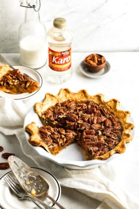 A sweet potato pie with pecan topping with a few slices missing